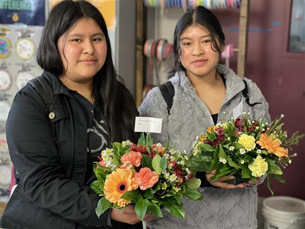 Floriculture students with table centerpieces made to take home and enjoy